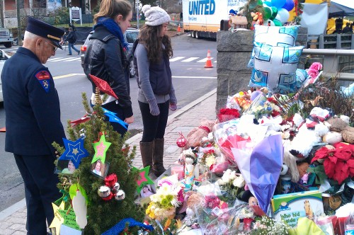 Caitlin Nosal (center) and her friend, who is a resident of Newtown, Conn., and former Old Lyme Selectman Mervin Roberts (left) look at some of the memorials to the 26 teachers and students killed at Sandy Hook Elementary School on Dec. 14.