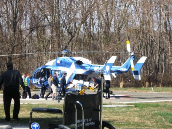 A wounded State trooper is transported towards the waiting Life Star helicopter.