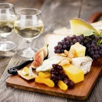 A delectable cheeseboard filled with an assortment of fine imported cheeses and served with dessert wine.  Shallow dof.