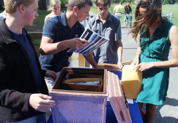 Senior Morgan White inserts a poster showing images of the high school into the capsule.