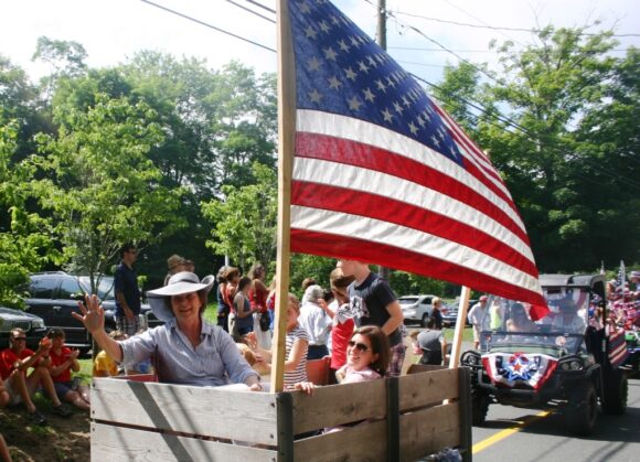 Carleen Gerber waves accompanied by her smiling daughter Allison (right) and grandchildren.