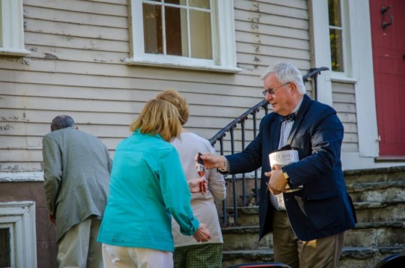President Dr. Scott Colleye hands out paintbrushes to the guests painting the ceremonial first strokes on the Sill House.