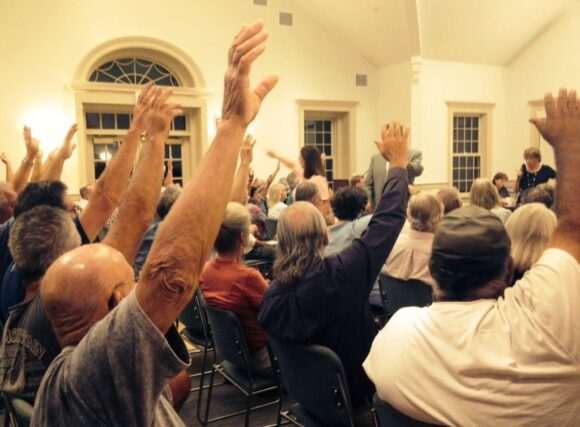 Democracy in action: First Selectwoman Bonnie Reemsnyder counts raised hands during Tuesday night's vote on dredging. 