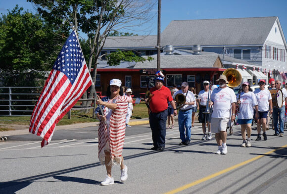 Joann Leishing leads the parade waving her flag while also wearing a flag ... and her omnipresent smile.