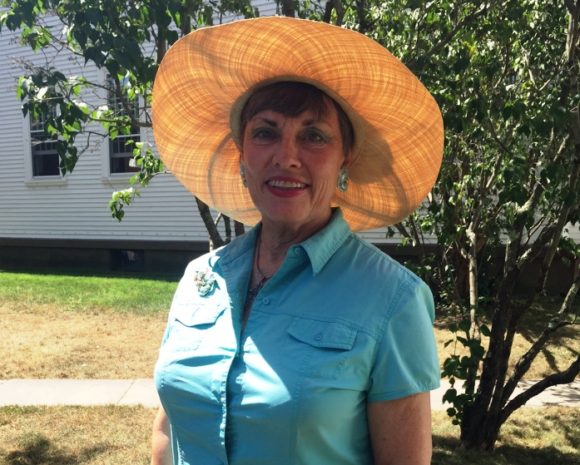 Curach rower Maureen Plumleigh stands in front of Old Lyme's Congregational Church wearing one of her delightful, signature hats.