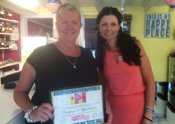 Barbara Crowley, owner of The Chocolate Shell (left) stands with OL-PGN Children's Librarian Julie Bartley after Bartley has presented Crowley with a certificate in appreciation of her support of the Summer Reading Program.