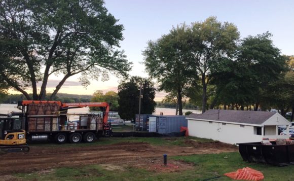 Construction equipment being used during the project stands on the site in front of Rogers Lake.