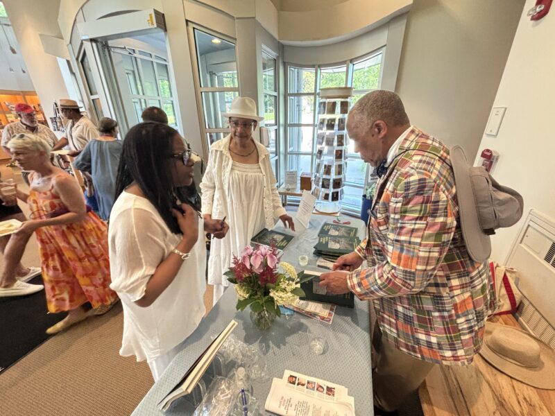 Photographer William Earle Williams signs copies of the exhibition catalogue for poets Rhonda Ward, left, and Kate Rushin.